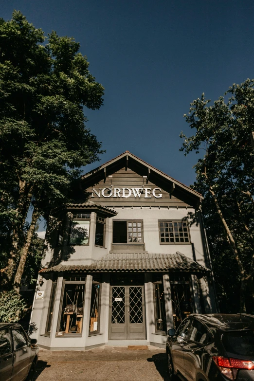 a couple of cars parked in front of a building, an album cover, inspired by Sven Nordqvist, reddit, northwest school, restaurant exterior photography, in karuizawa, profile image, wilderness ground