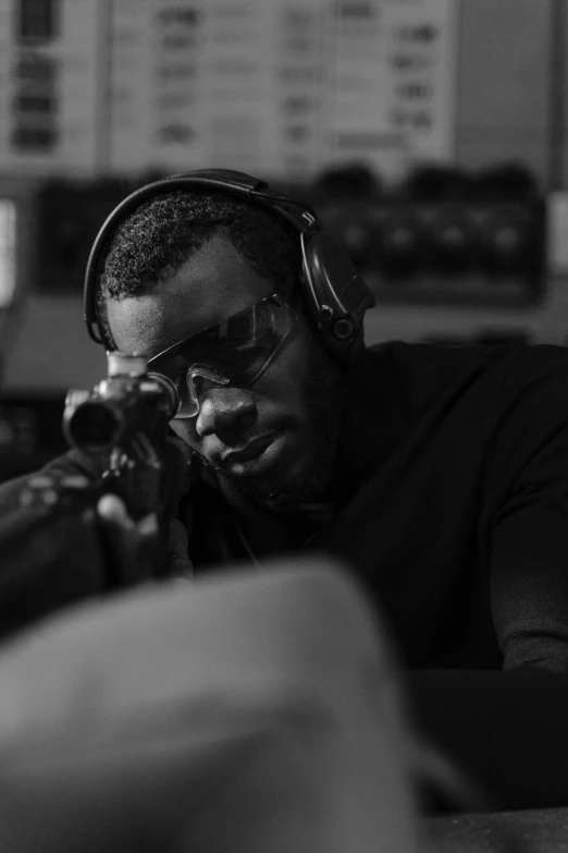 a man sitting at a table with headphones on, an album cover, unsplash, firing a gun, sharp black skin, profile picture, profile picture 1024px