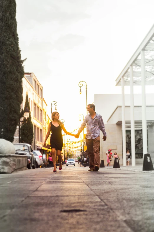 a man and a woman walking down a sidewalk, pexels contest winner, marbella, square, downtown mexico, sunset