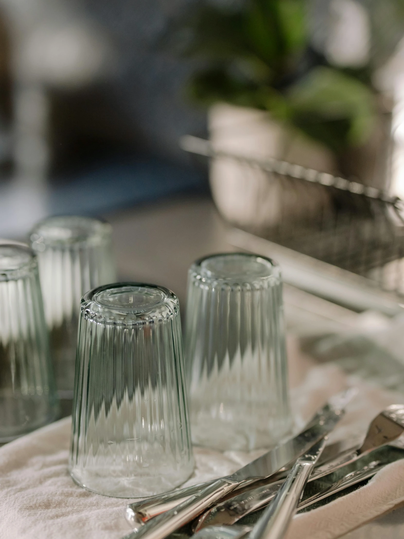 a bunch of silverware sitting on top of a table, plants in glasses, textured base ; product photos, striped, medium close shot