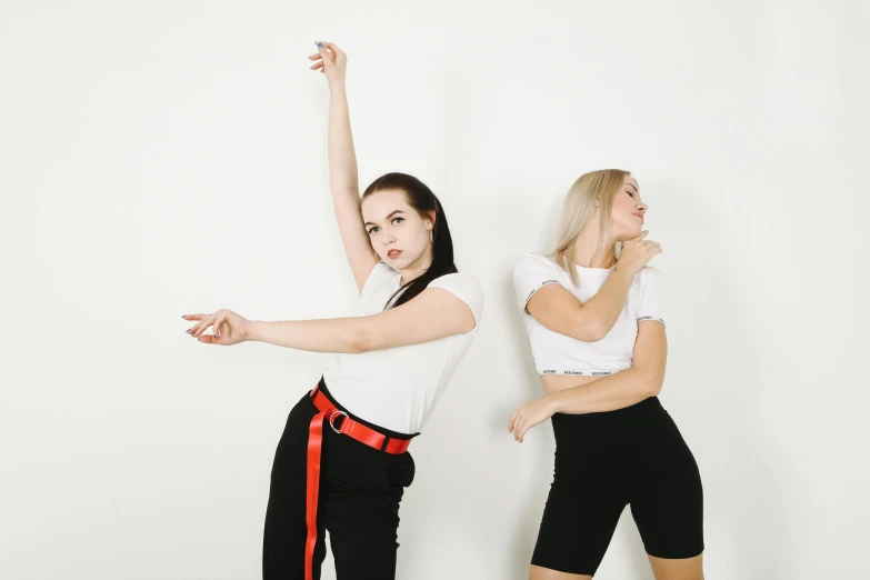 a couple of women standing next to each other, trending on pexels, frantic dancing pose, white backdrop, parody work, band