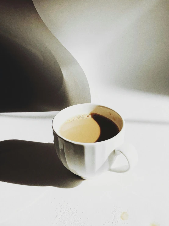 a cup of coffee sitting on top of a table, by Rebecca Horn, sun puddle, detailed product image