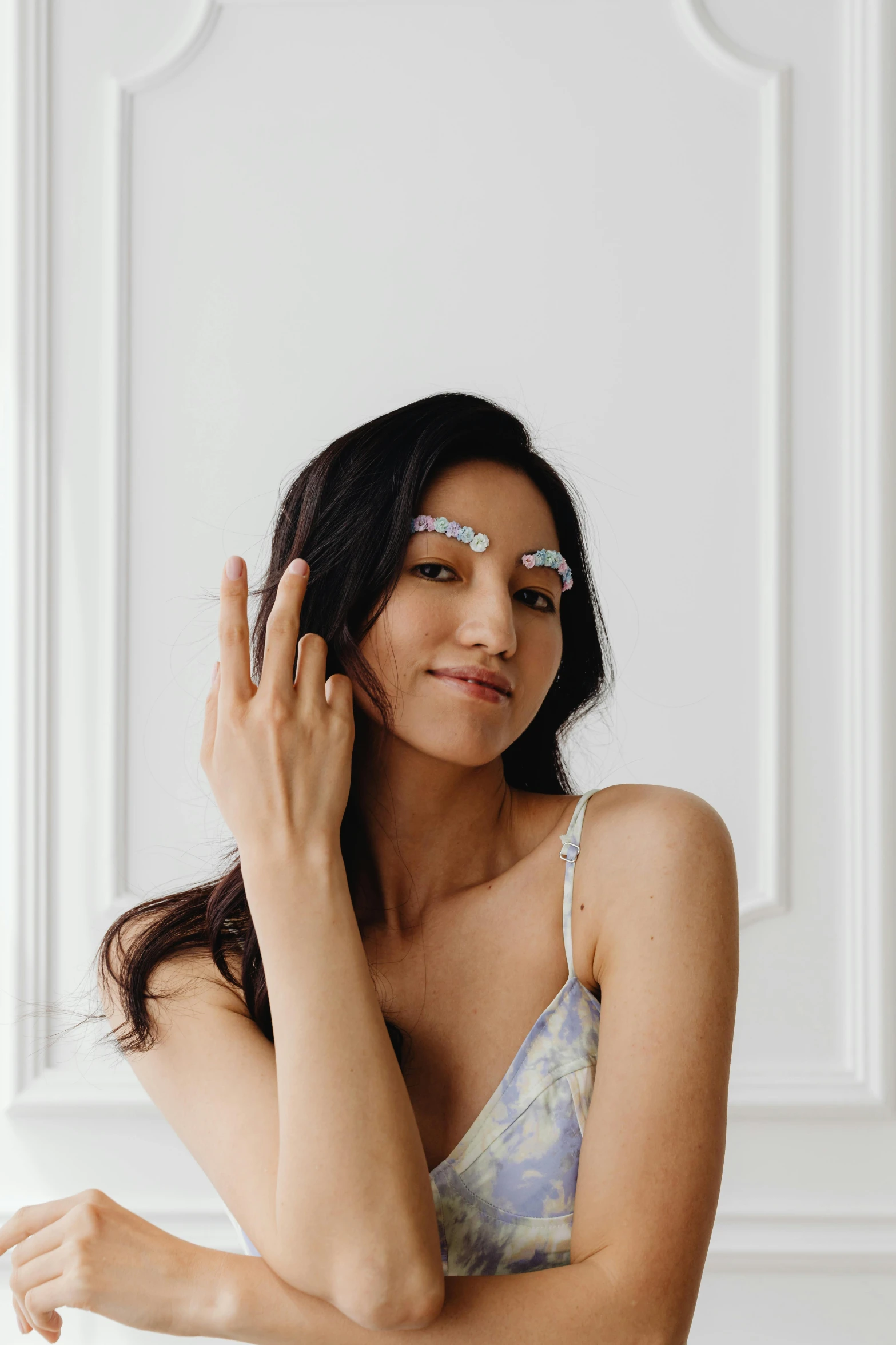 a woman sitting on top of a bed next to a window, a colorized photo, by Nicolette Macnamara, trending on pexels, jeweled ornament over forehead, skincare, wearing a patch over one eye, set against a white background