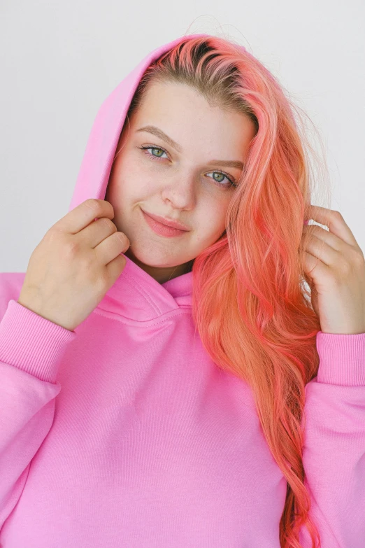 a woman with pink hair wearing a pink hoodie, a colorized photo, trending on pexels, long wavy orange hair, ruan cute vtuber, emily rajtkowski, 🤤 girl portrait