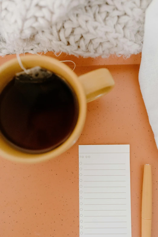 a cup of coffee and a notepad on a table, trending on pexels, postminimalism, black and orange colour palette, thumbnail, jen atkin, promo image