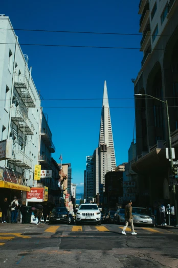 a city street filled with lots of traffic and tall buildings, lead - covered spire, sf, blue sky, cinematic image