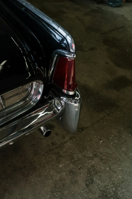 a black car is parked in a garage, by Sven Erixson, unsplash, photorealism, tail lights, silver crown, william eggleston, low quality photo