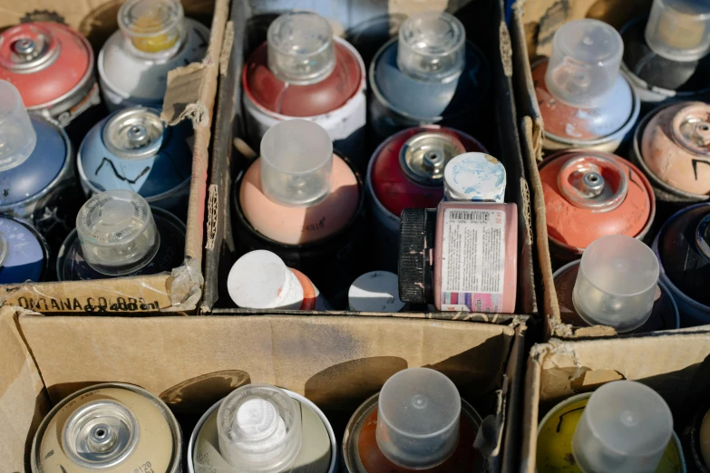 a box filled with lots of different types of spray paint, an airbrush painting, by Paul Davis, unsplash, scrapyard, brown, instagram post, tape