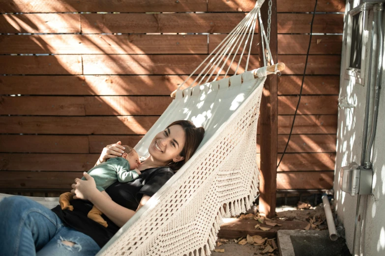 a woman holding a baby in a hammock, a portrait, inspired by Elsa Bleda, pexels contest winner, renaissance, sunny day time, avatar image, macrame, zigor samaniego style