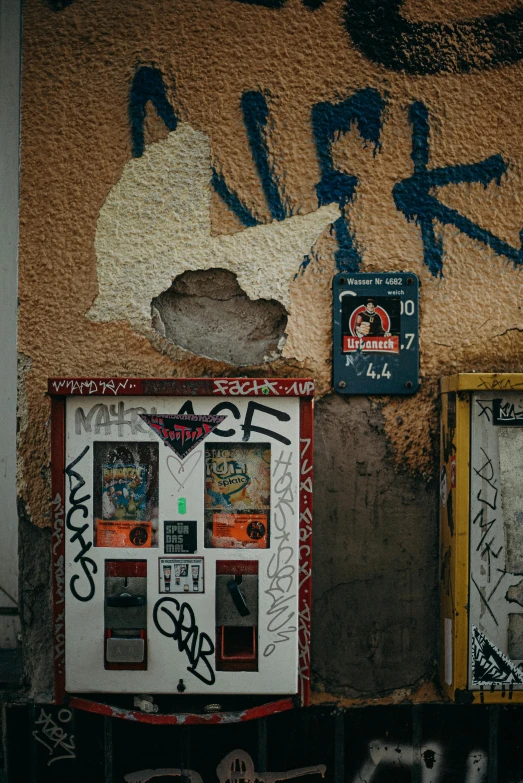 a couple of vending machines sitting on the side of a building, a photo, pexels contest winner, graffiti, shattered crumbling plaster, berlin, an escape room in a small, background image