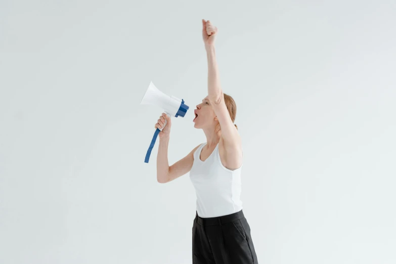 a woman in a white tank top and black skirt holding a blue and white megaphone, pexels, figuration libre, background image, scolding, with a white background, holding a staff