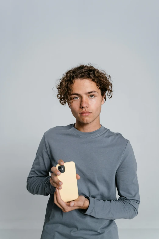 a man holding a cell phone in his hand, lean man with light tan skin, curly haired, gen z, product image