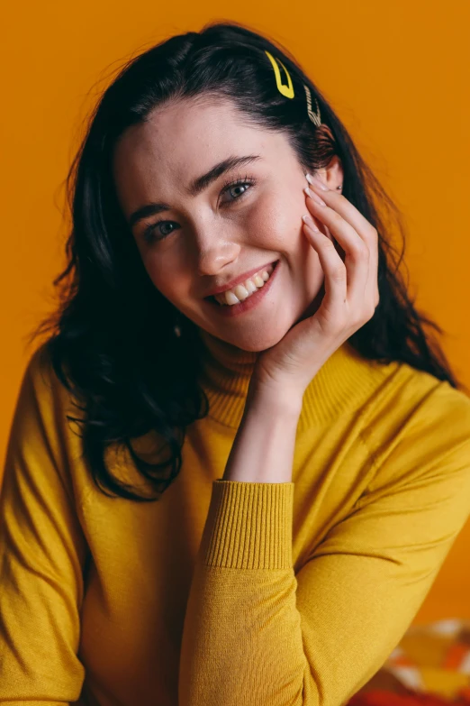 a woman in a yellow sweater posing for a picture, a character portrait, trending on pexels, lilly collins, happy grin, studio photo, orange