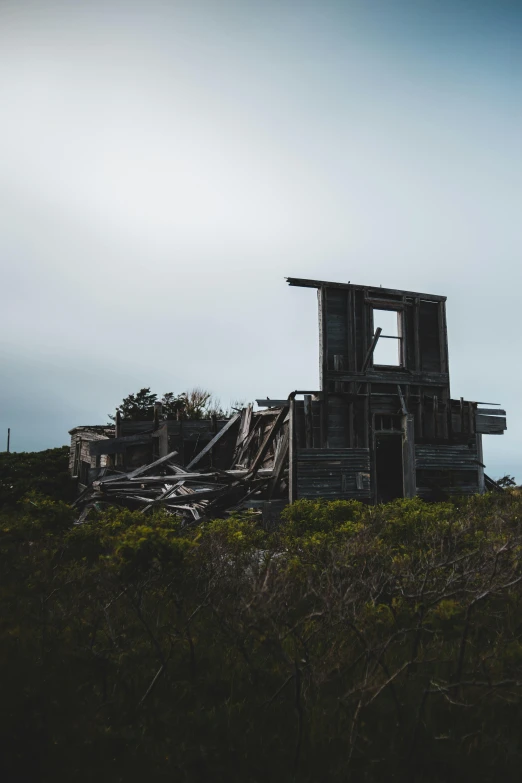 a tall tower sitting on top of a lush green hillside, an album cover, unsplash, dilapidated house, post apocalyptic san francisco, profile image, shipwreck