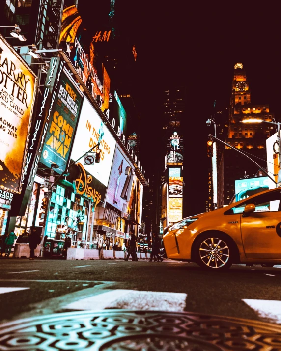 a yellow car driving down a city street at night, time square, thumbnail, billboard image, unsplash photography