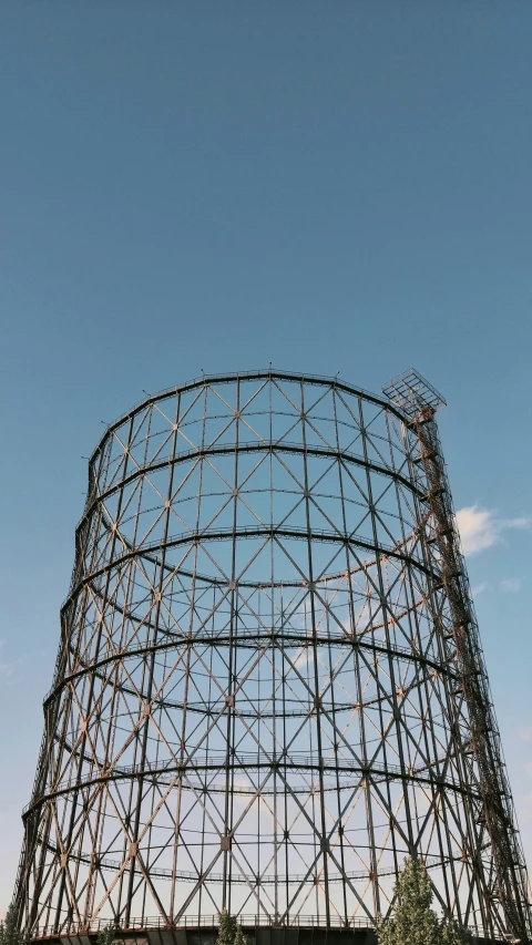 a large metal structure sitting in the middle of a field, unsplash, former gasometer in rome, clear sky, high quality photo, no logo