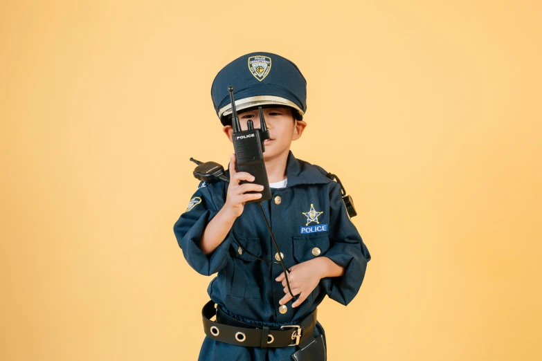 a little boy dressed up as a police officer, a cartoon, trending on pexels, phone!! held up to visor, cosplay photo, bella poarch, full device