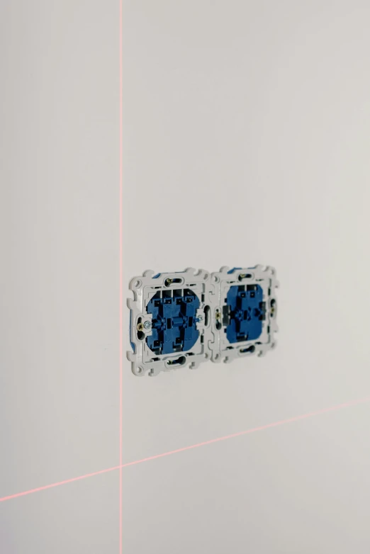 a pair of blue stud earrings sitting on top of a white surface, an album cover, inspired by Richard Anuszkiewicz, unsplash, conceptual art, lasers and neon circuits, the walls are pink, pacing in server room, detail shot