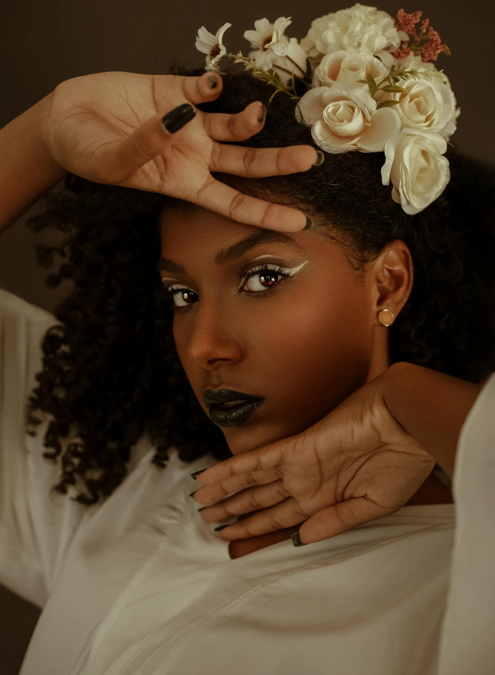 a woman with a flower in her hair, by Lily Delissa Joseph, trending on unsplash, afrofuturism, cool sepia tone colors, with professional makeup, hands behind her pose!, black curly hair