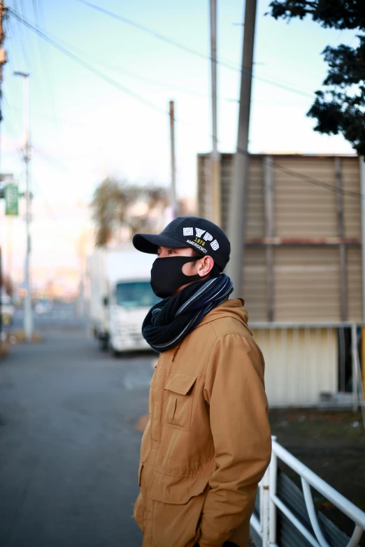 a man standing on the side of a road, by Miyamoto, unsplash, lyco art, black bandana mask, profile image, in front of a garage, winter season