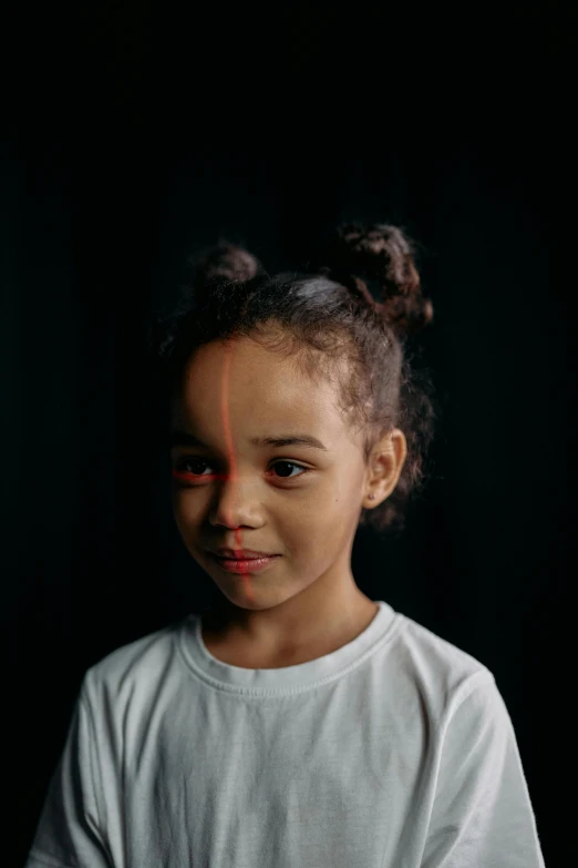 a little girl standing in front of a black background, markings on his face, varying ethnicities, left eye red stripe, wide forehead