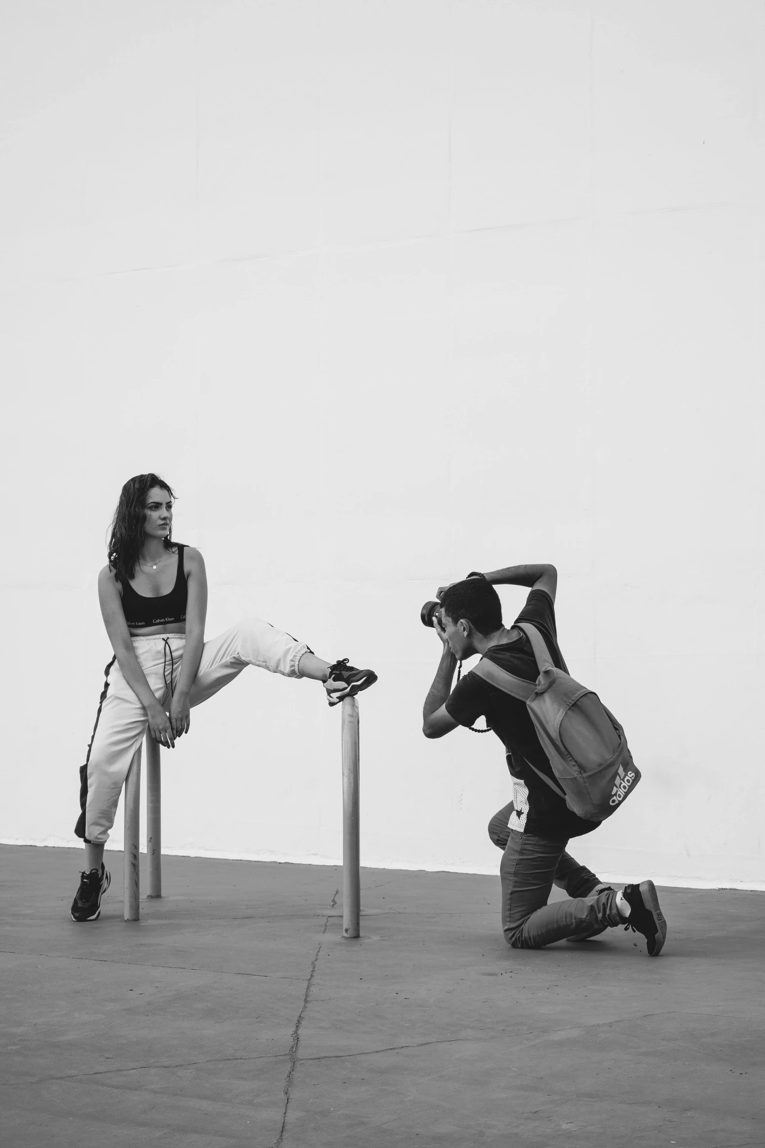 a black and white photo of a man taking a picture of a woman, a black and white photo, by Alexis Grimou, crouching, :: madison beer, tourist, choreographed