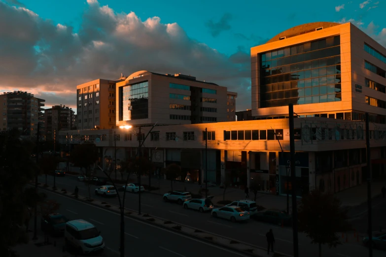 a street filled with lots of traffic next to tall buildings, by Michalis Oikonomou, pexels contest winner, hyperrealism, orange and cyan lighting, medical complex, late afternoon lighting, brutalism style