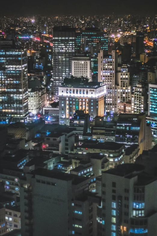 an aerial view of a city at night, trending on unsplash, modernism, in sao paulo, zoomed in, night life buildings, 8k resolution”