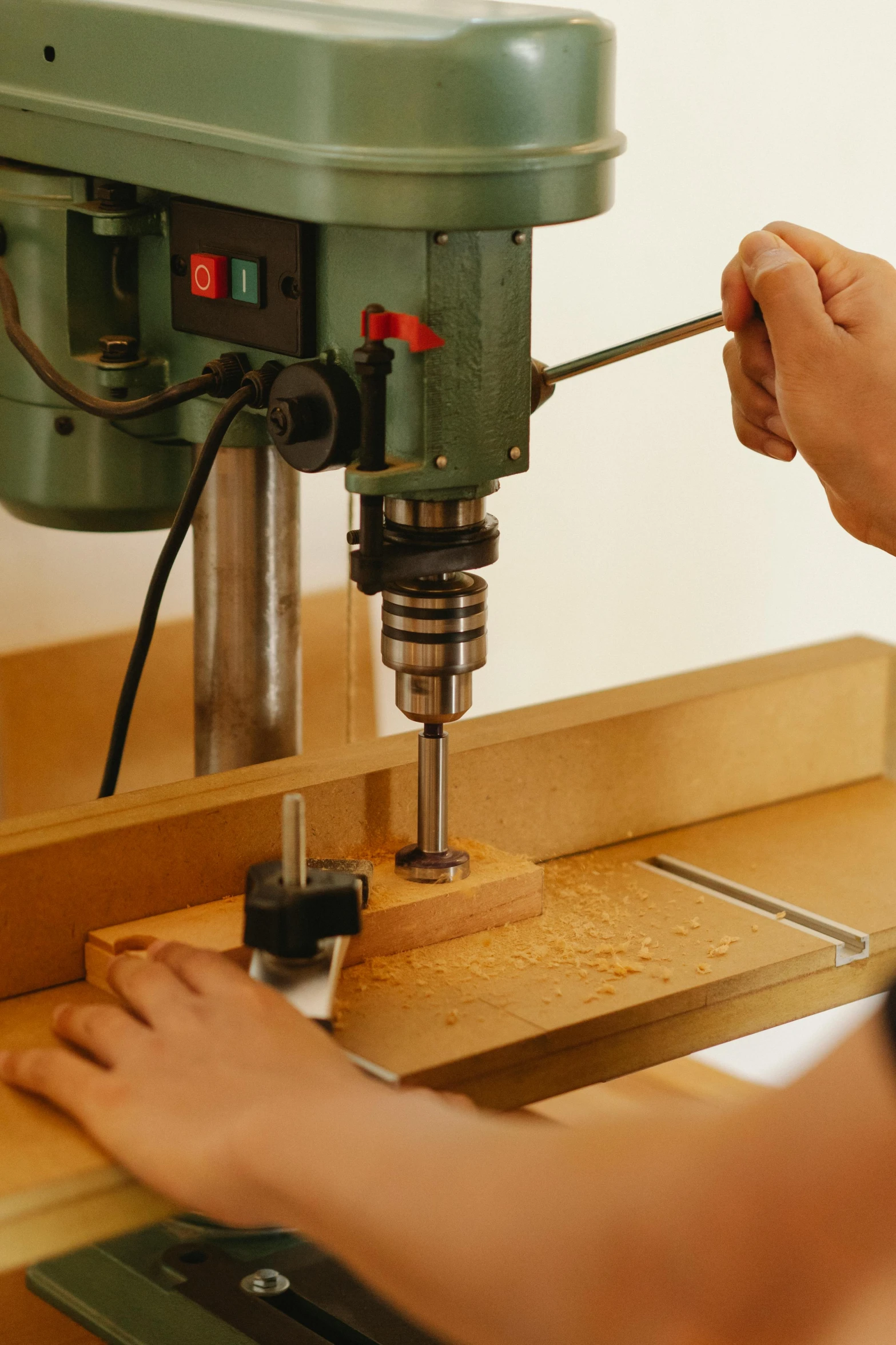 a person using a drill to drill a piece of wood, private press, bespoke, with mechanical arms that fix it, australian, educational