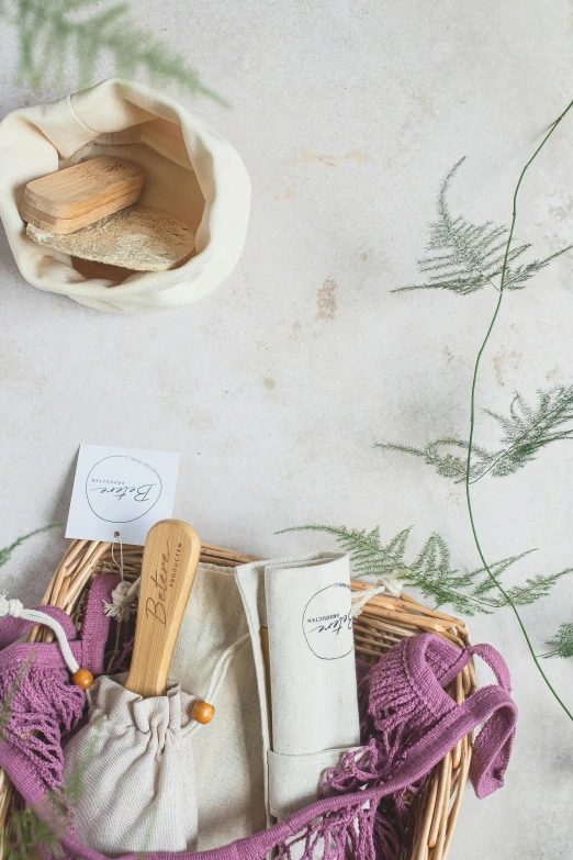 a basket filled with items sitting on top of a table, inspired by Eden Box, unsplash, lavender blush, toddler, sustainable materials, studio photograph