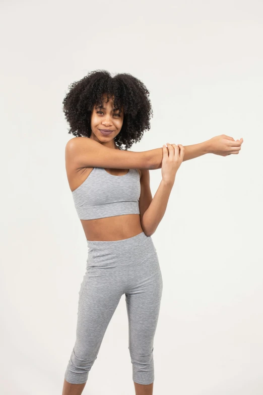 a woman in a sports bra top and leggings, trending on pexels, arms extended, light grey, ashteroth, product introduction photo
