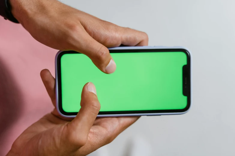 a person holding a smart phone with a green screen, by Carey Morris, trending on pexels, pink white and green, green square, gradient green black, on a gray background