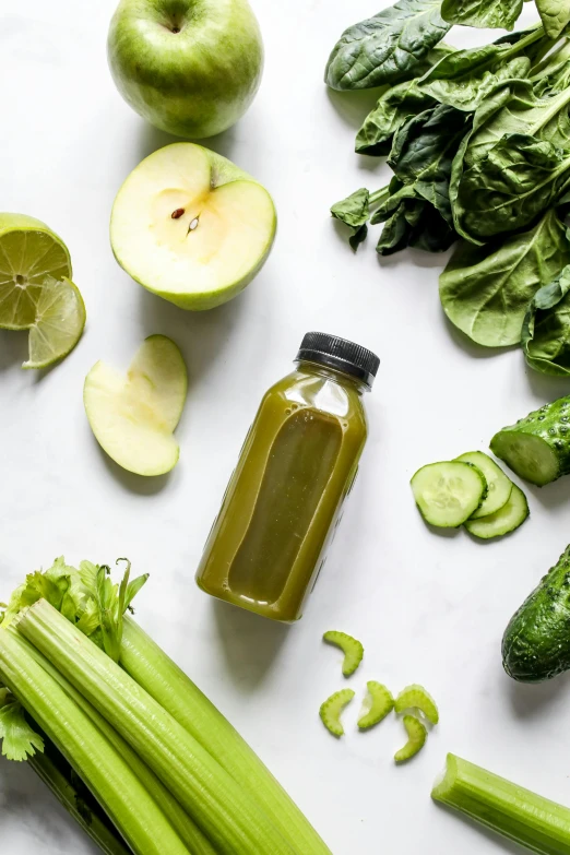 a table topped with green vegetables and a bottle of juice, a picture, pexels, black on white background, apple, lime, blending