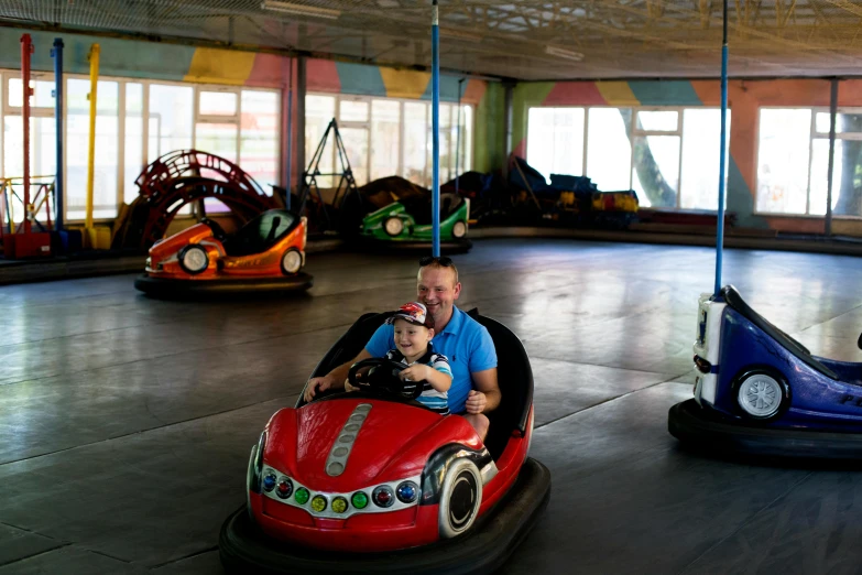 a man and a boy are sitting in bumper cars, lachlan bailey, indoor picture, swings, 15081959 21121991 01012000 4k