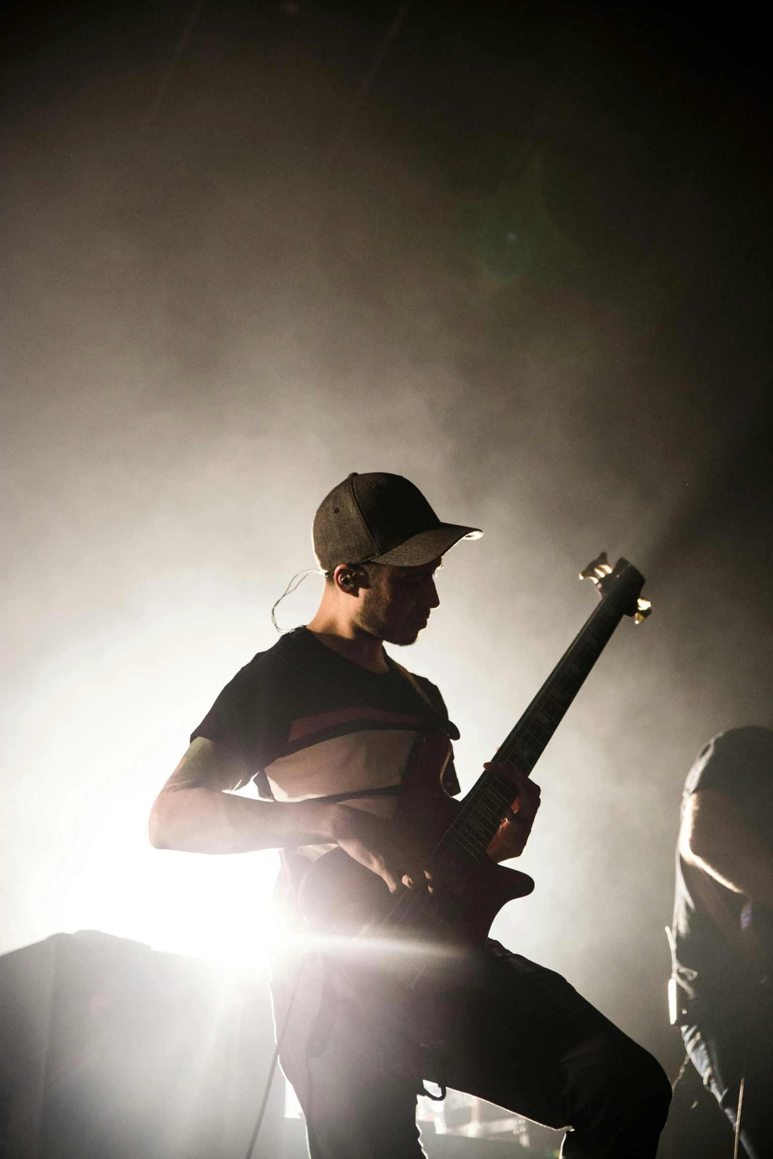 a man holding a guitar on top of a stage, by Robbie Trevino, shigeto koyama, demon days, sports photo, hazy