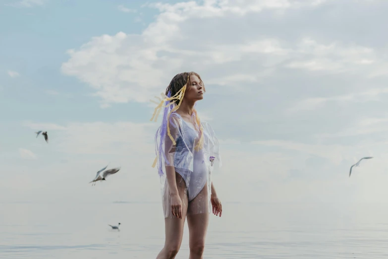 a woman standing in the ocean surrounded by seagulls, by Emma Andijewska, conceptual art, wings lace wear, soft lilac skies, portrait of teenage aphrodite, shot with sony alpha 1 camera