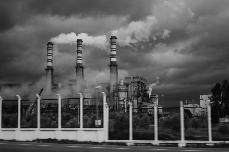 a black and white photo of a factory with smoke coming out of it, a black and white photo, by Kristian Zahrtmann, pexels contest winner, surrealism, power plants, a green, on a cloudy day, stylized illustration