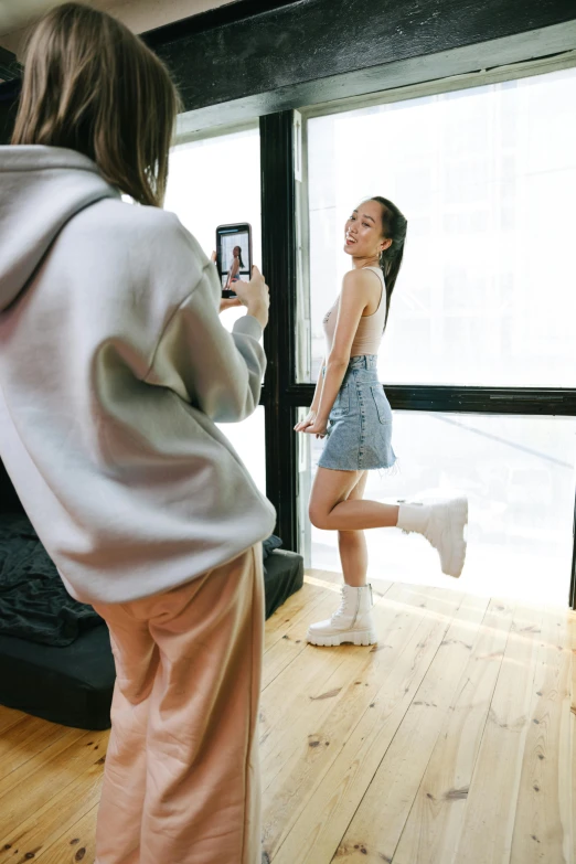 a woman standing in a living room taking a picture of herself, inspired by Wang E, bra and shorts streetwear, in an action pose, lulu chen, vs studio