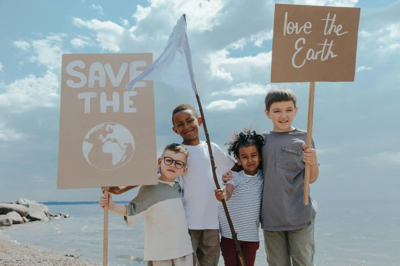 a group of children holding signs that say save the earth, by Emma Andijewska, pexels contest winner, coastal, avatar image, brown, holding a white flag