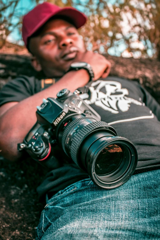 a man laying on the ground with a camera, by Hubert van Ravesteyn, pexels contest winner, headshot profile picture, canon on chest, low detailed, music video