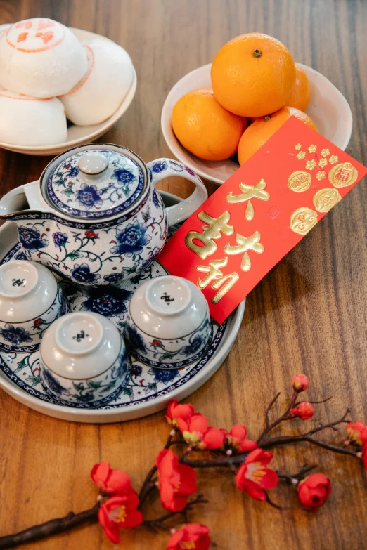 a tea set sitting on top of a wooden table, a portrait, inspired by Cui Bai, pexels, festive, square, 千 葉 雄 大, celebration