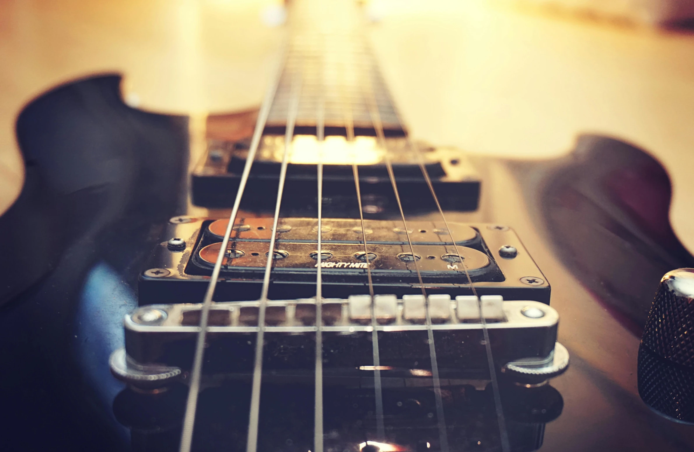 a guitar sitting on top of a wooden table, by Joe Bowler, pexels contest winner, wires and strings, rectangle, close up shots, extremely high fidelity