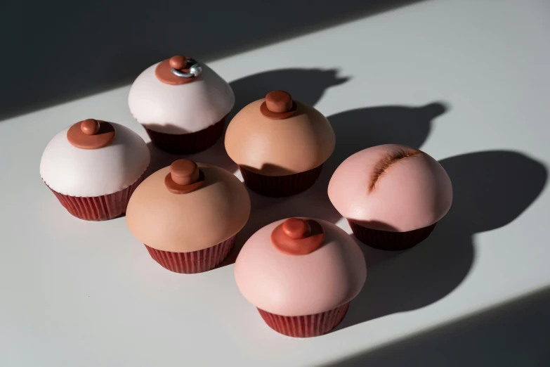 a group of cupcakes sitting on top of a table, inspired by Douglas Bourgeois, silicone skin, terracotta, smooth matte, pout