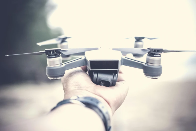 a close up of a person holding a small drone, pexels contest winner, avatar image, 1 2 9 7, fan favorite, flying vehicles