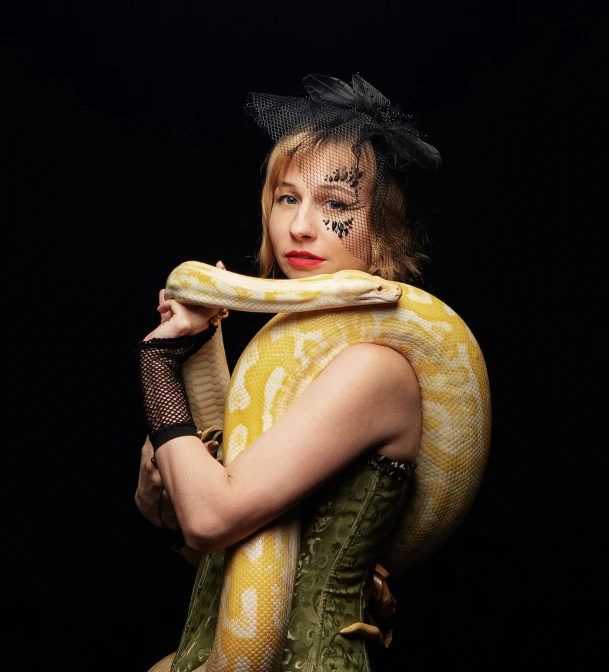 a woman with a snake around her neck, an album cover, trending on pexels, zoe kazan, michael hussar, reptiles, taken with sony alpha 9