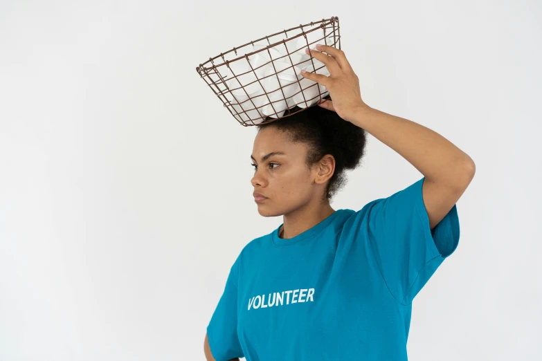 a woman with a basket on her head, by Nina Hamnett, unsplash, wearing a t-shirt, teal uniform, with a white background, made of wire