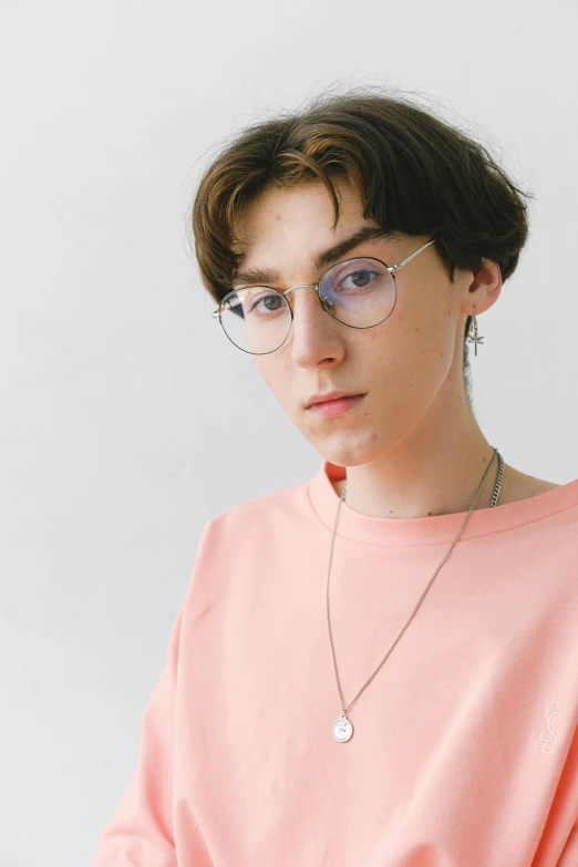 a woman wearing glasses and a pink shirt, inspired by Yanjun Cheng, trending on unsplash, neo-dada, portrait of timothee chalamet, cyber necklace, young anime man, official store photo