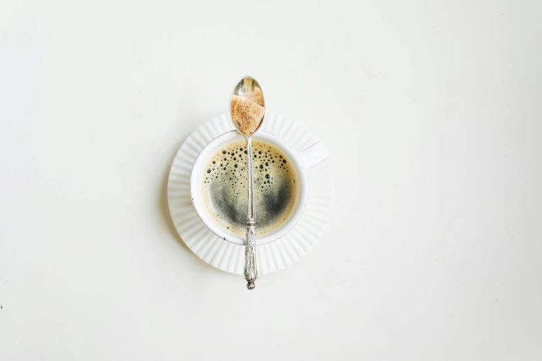 a cup of coffee with a spoon in it, by Jan Kupecký, trending on pexels, postminimalism, white backround, silver，ivory, 15081959 21121991 01012000 4k, instagram post