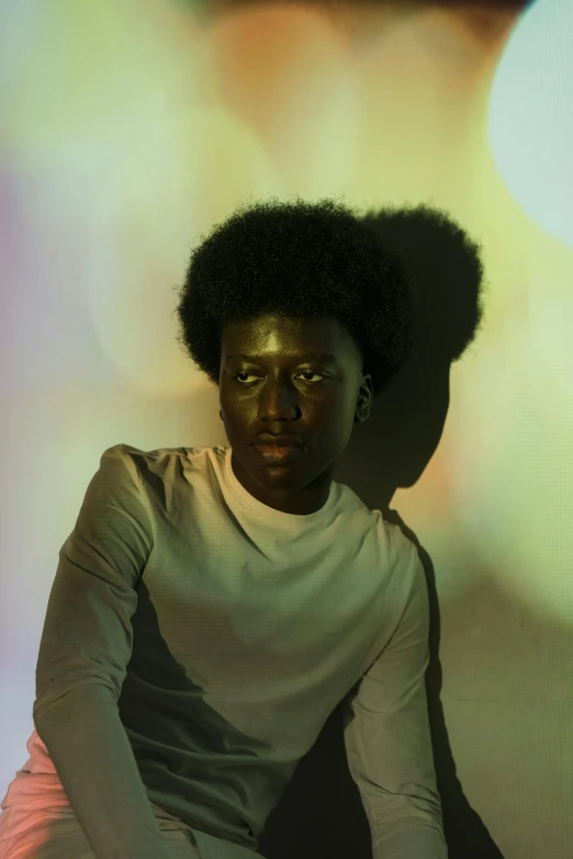 a man sitting on a stool in front of a wall, by Nathalie Rattner, pexels contest winner, afrofuturism, iridescent skin, with afro, soft backlight, black on white background
