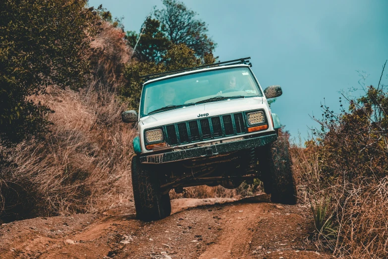 a white jeep driving down a dirt road, pexels contest winner, renaissance, avatar image, 90's photo, action sports, front of car angle